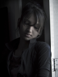 An Indian women leaning against a door